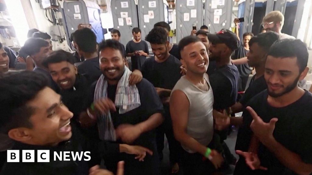 Migrants celebrate and dance after being rescued