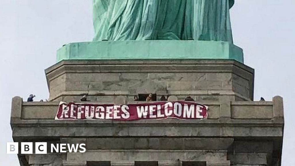 'Refugees banner hung on Statue of Liberty in New York BBC News