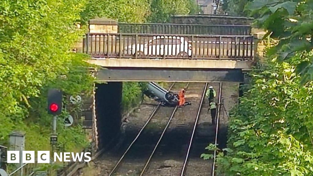 Trains cancelled after car crashes onto tracks
