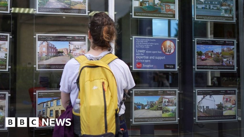 Woman looking at estate agents window