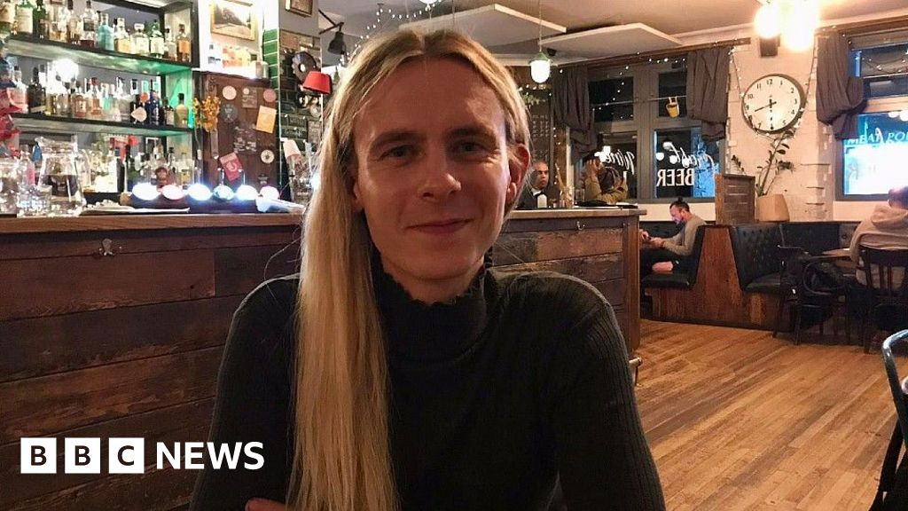 Alex Garden sitting in the Greenbank Pub. They have long blonde hair and are wearing a dark top.