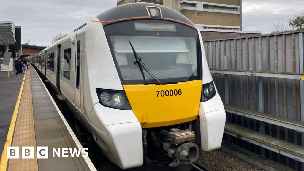 Thameslink train shows white and yellow frontage at a platform on a grey day