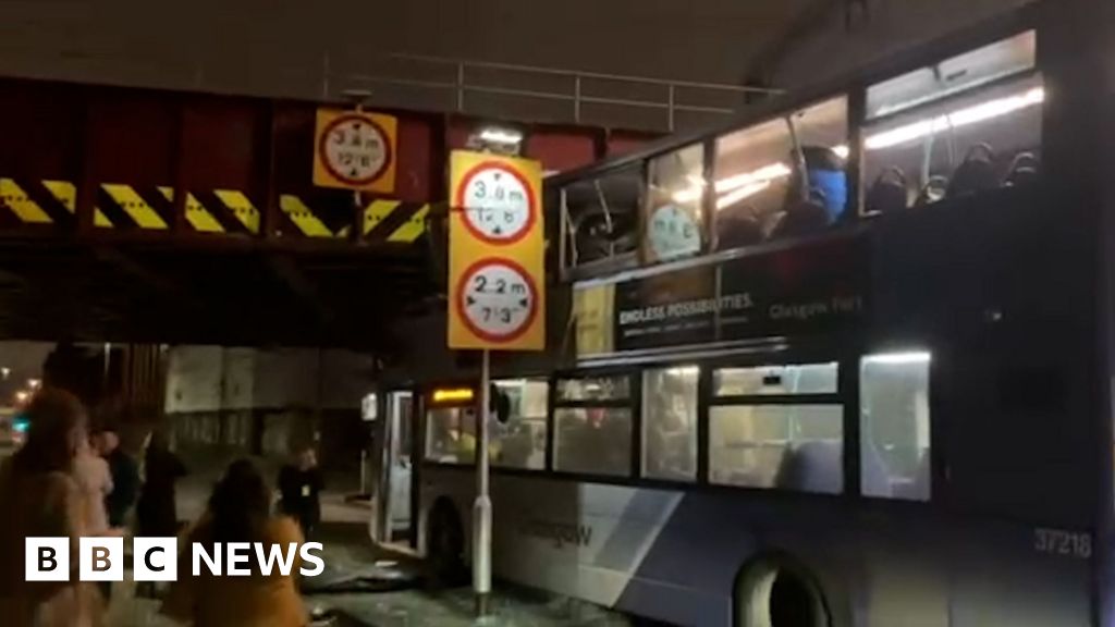 Double decker bus wedged under bridge after crash