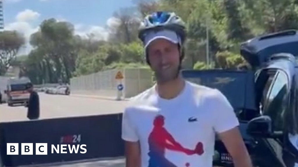 Djokovic greets followers with a helmet after being hit by bottle