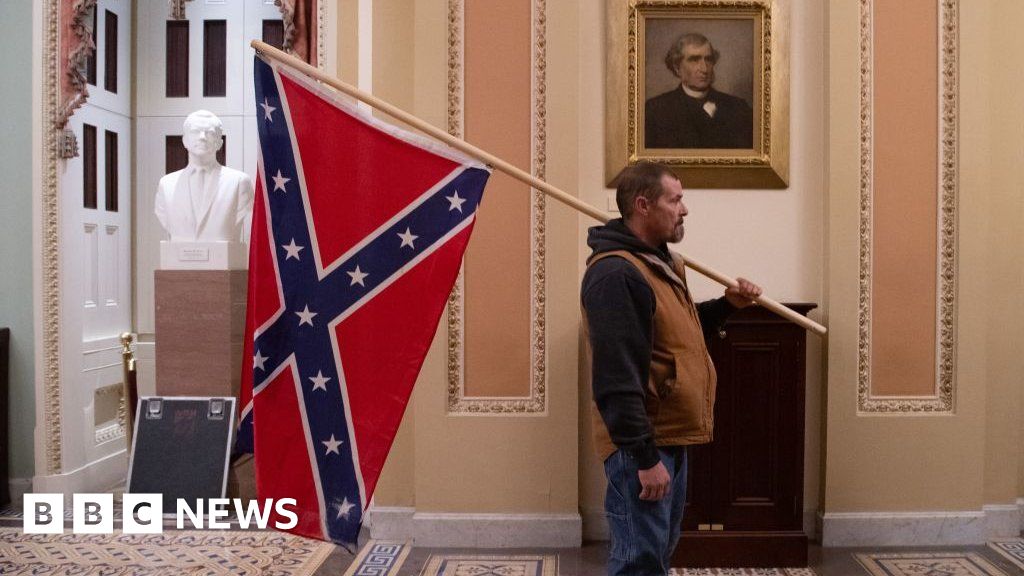 Capitol rioter who jabbed Confederate flag at black cop jailed