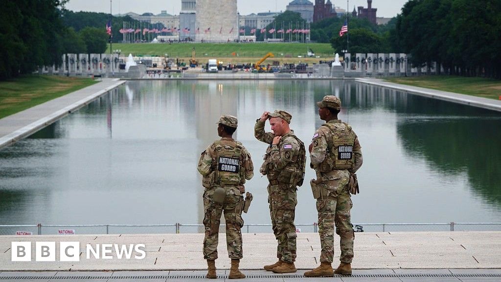 Photo: BBC Three members of the National Guard stand in front of the Reflecting Pool