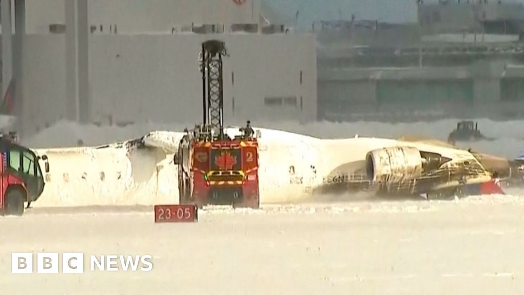 Pesawat terbalik terletak di landasan pacu Bandara Toronto Pearson setelah kecelakaan