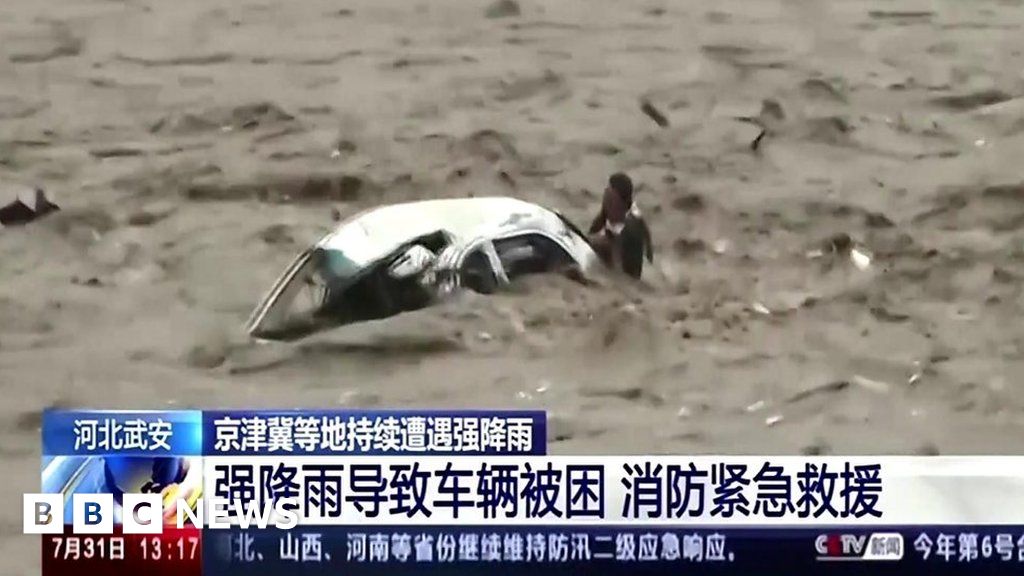 China floods: Man rescued from overturned car