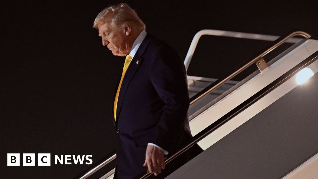 Donald Trump walking down steps of Air Force One, looking downwards