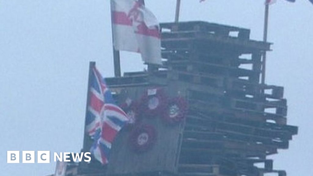 Flags and poppy wreaths on a bonfire in Creggan in 2023