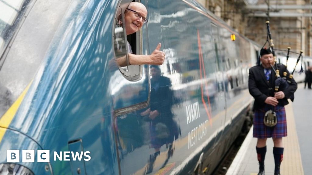 A piper plays as train driver Neil Barker gives a thumbs up from on board the Avanti West Coast Class 390 EMU train which has arrived at Glasgow Central Station from London Euston