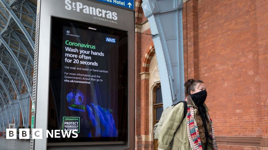 A woman leaving St Pancras International station wearing a mask