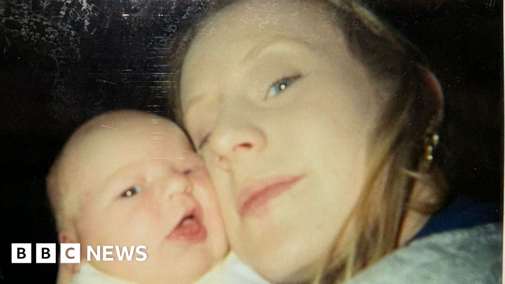 Sabrina Lyttle, then in her early 20s and with blonde hair and a gold earring, poses for a picture with her right cheek pressed against the cheek of her baby daughter