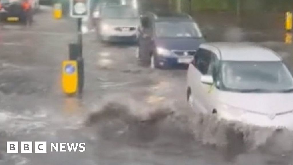Cars in London push through thunderstorm flooding