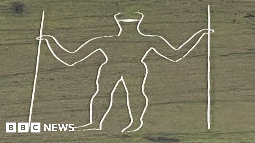 Long Man of Wilmington carving given face mask makeover - BBC News
