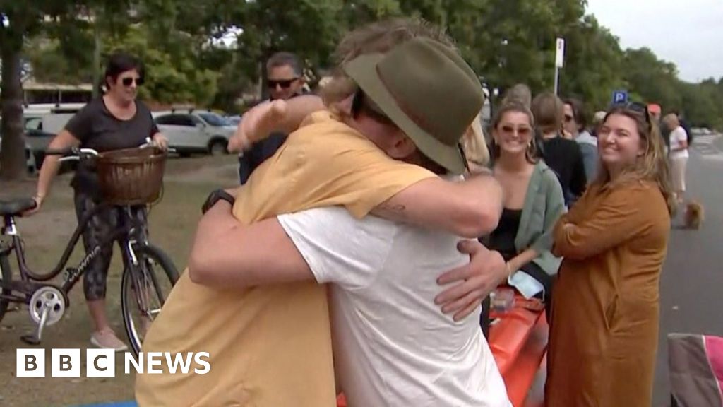 Covid: Separated Australian families swap hugs at border on Father's Day