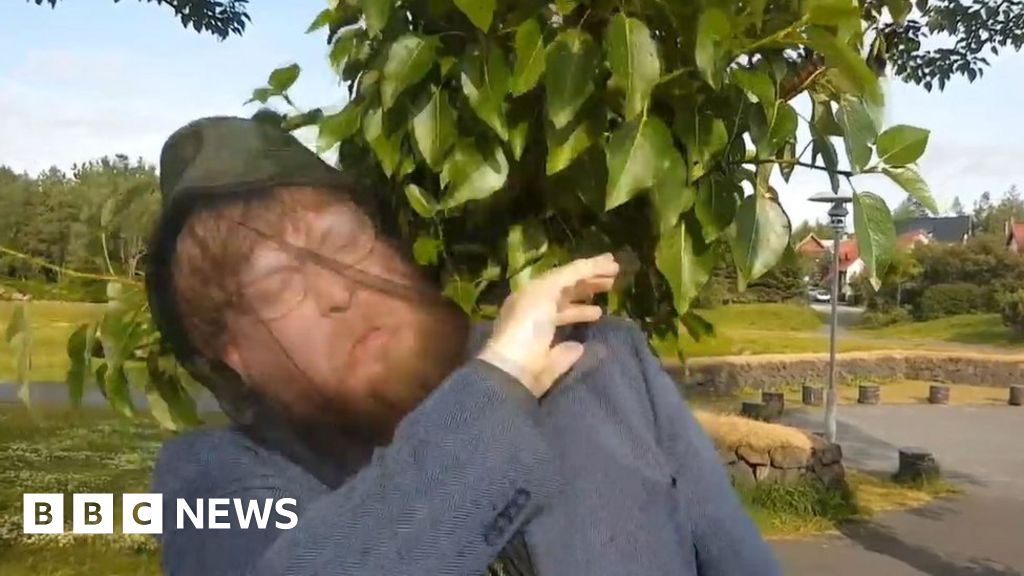 Man waving midges away in music video