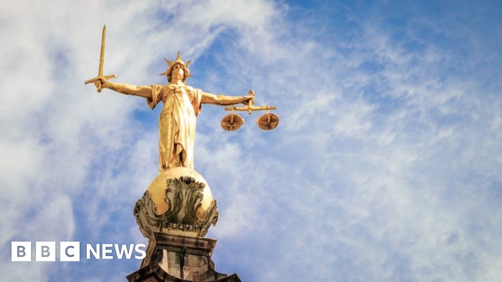 image of the statue of Lady Justice, holding a sword and weighing scales, located on top of the Central Criminal Court, known as the Old Bailey, in London.