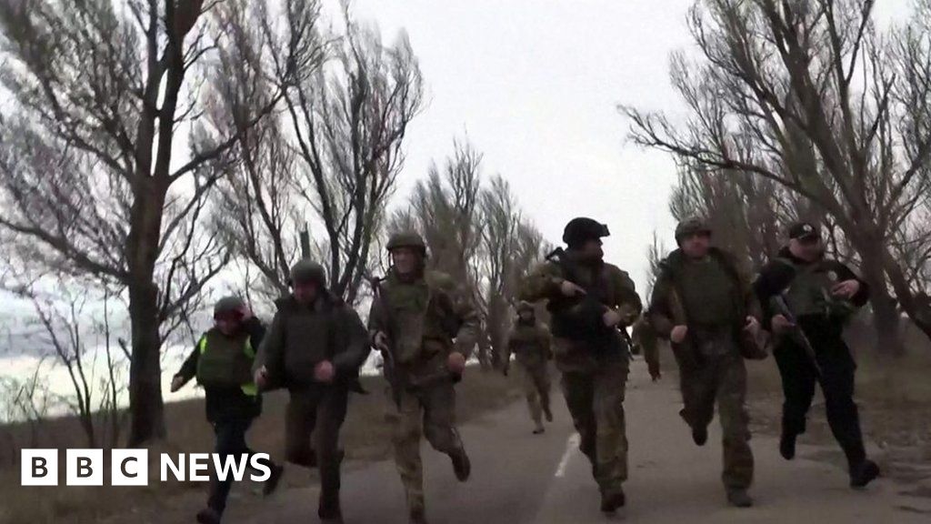 Ukrainian officials run from apparent shelling