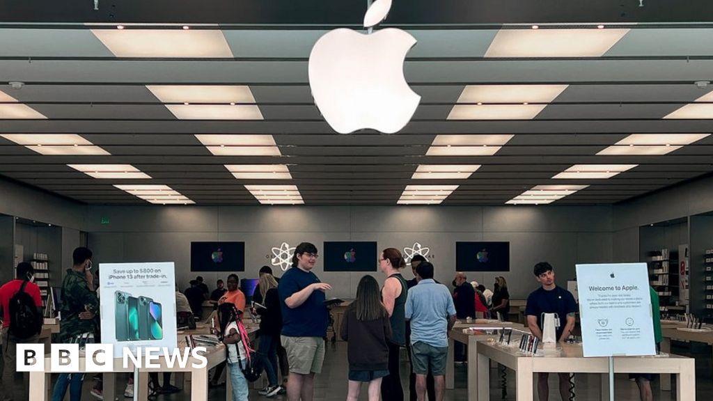 A passerby looks to the Apple Store now closed until March 27th at