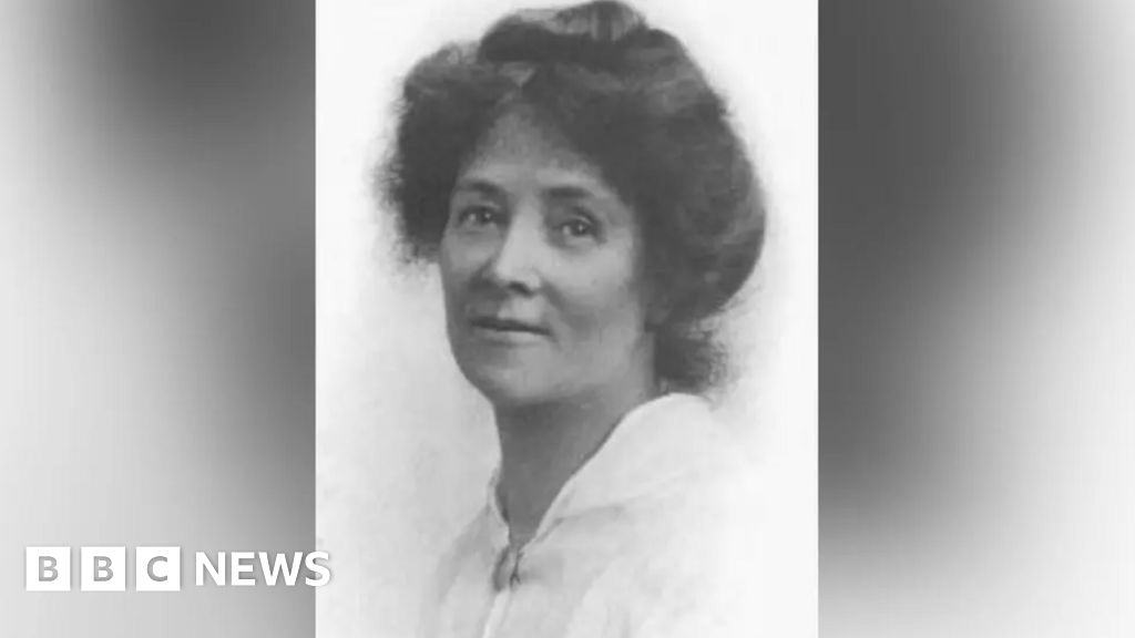 A black and white photo of Ada Nield Chew, wearing a white blouse. She has dark hair tied up on her head.