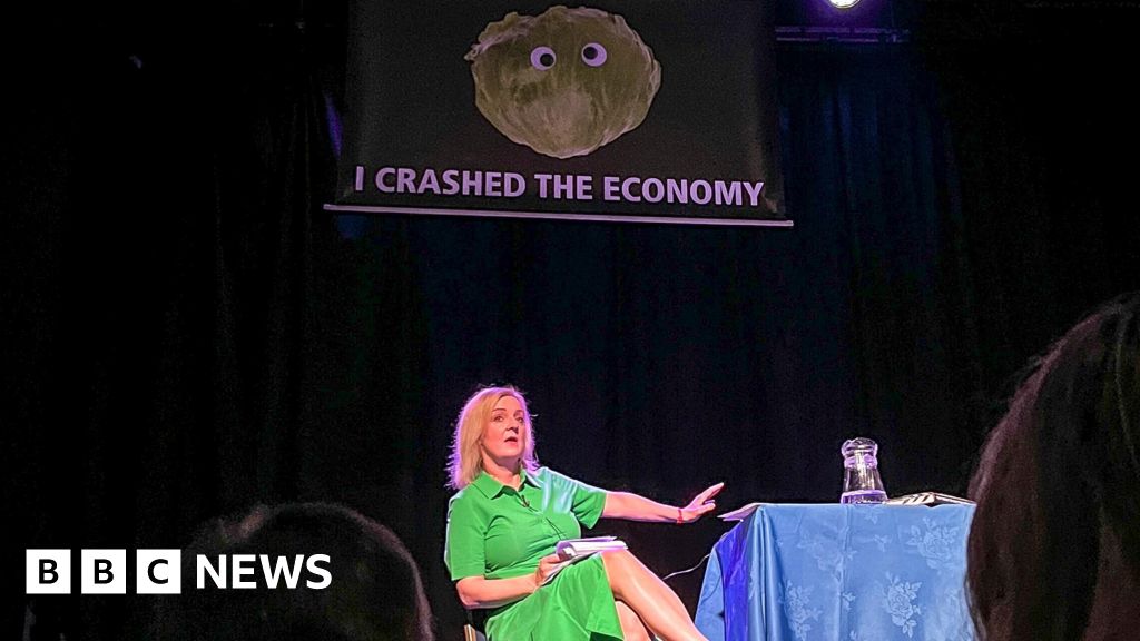 Liz Truss leaves stage as lettuce banner unfurls