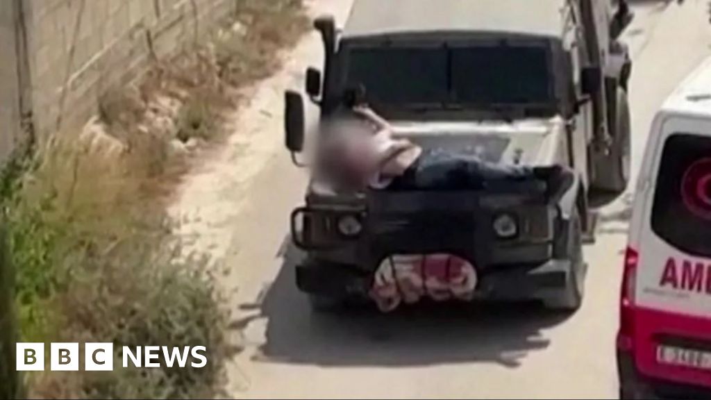 man strapped to jeep