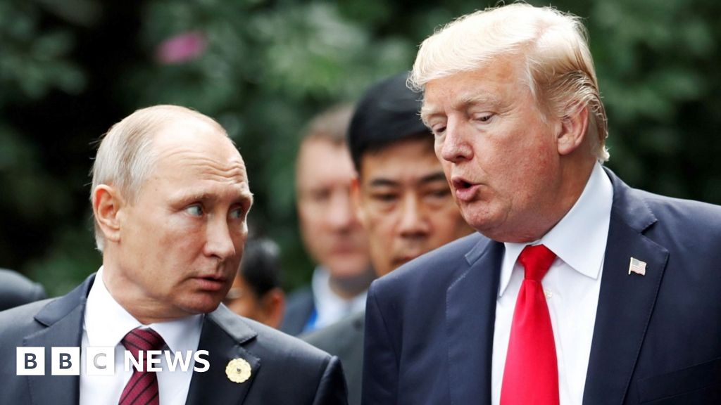 U.S. President Donald Trump and Russia"s President Vladimir Putin talk during the family photo session