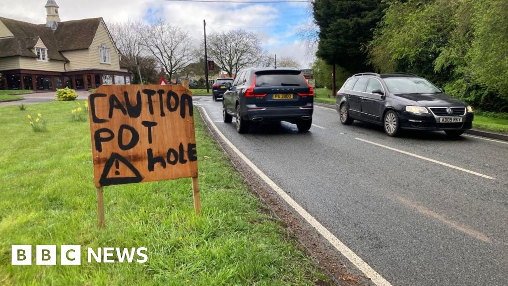 Sign warns of potholes outside Great Easton Rolls-Royce showroom