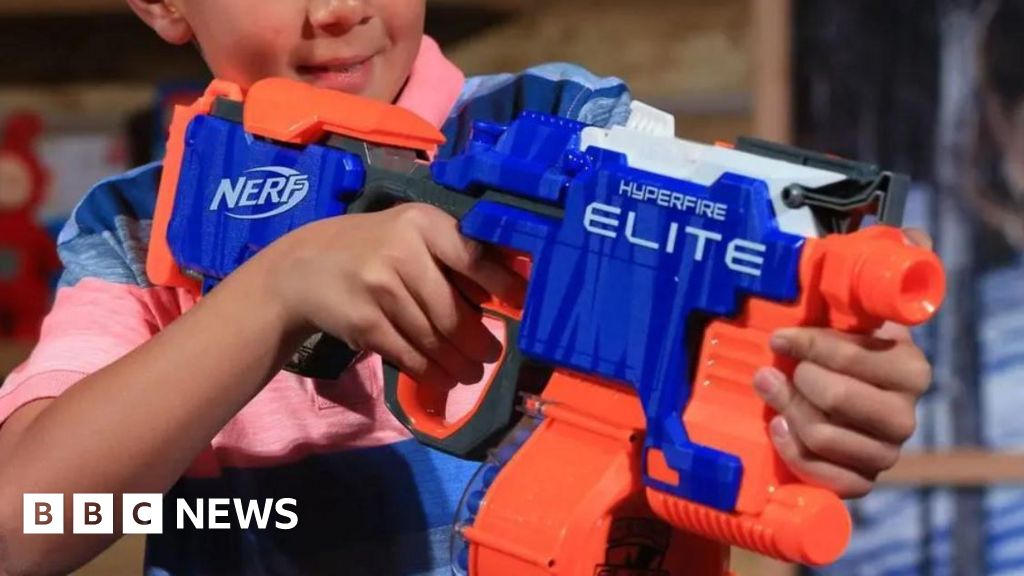 Anak laki -laki bermain dengan pistol nerf mampir di polisi bersenjata