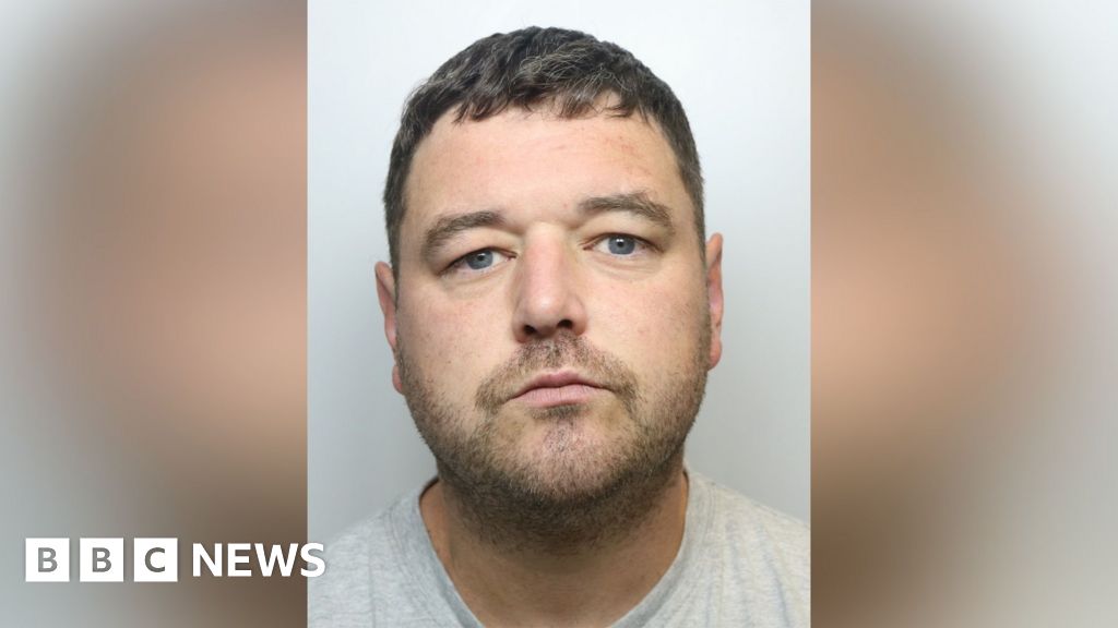 A man in his thirties, pictured in a police mugshot. He has short, mousy brown hair, blue eyes and stubble. He is wearing a grey t-shirt.