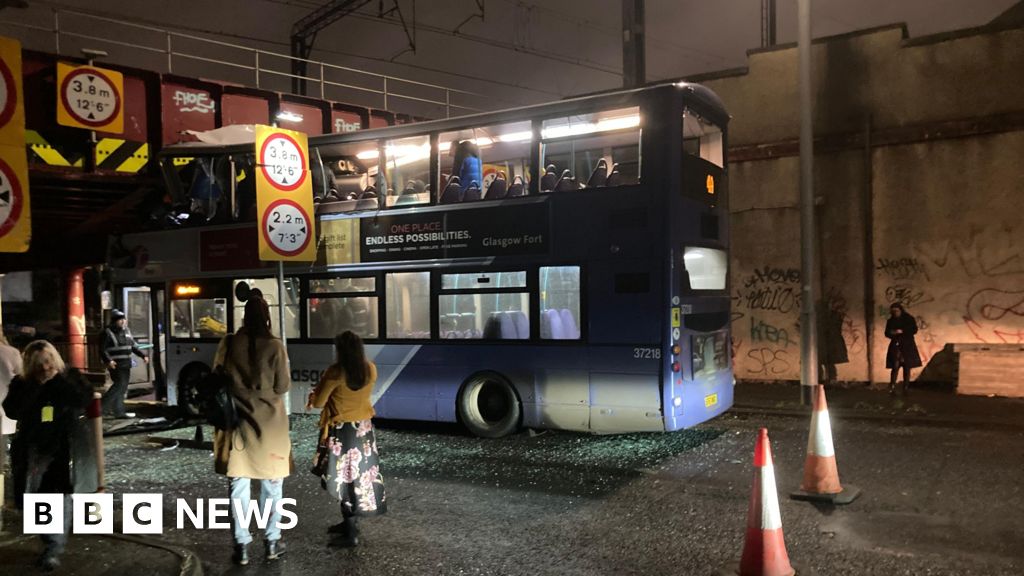 Roof torn off bus after railway bridge crash