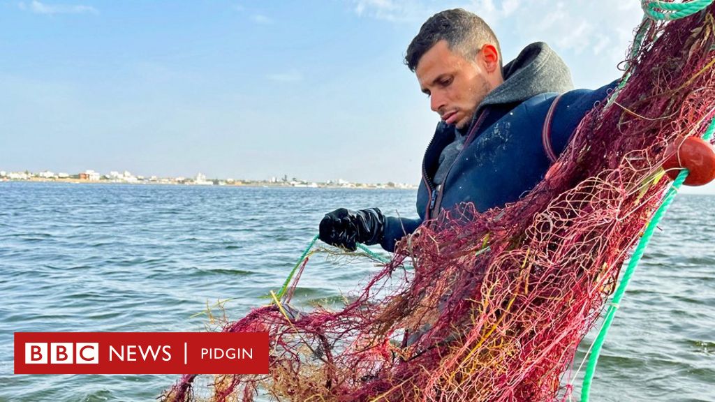 Man busy in knitting fish catching net to earn his livelihood for support  his family, on other hand fishing is ban due to rough sea, at Fishery in  Ibrahim Hyderi in Karachi