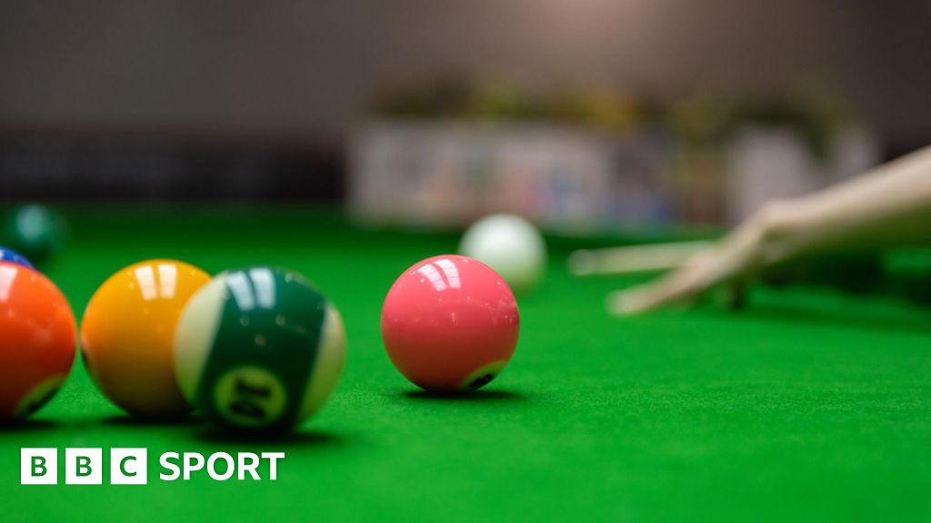 A player takes a shot during a game of pool