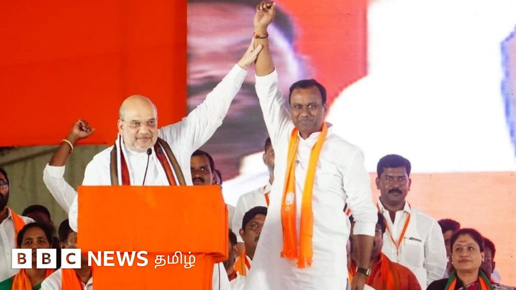 அமித் ஷாவின் காலணிகளை தூக்கிய பாஜக தலைவர் - 'குஜராத் அடிமைகள்' என்று விமர்சித்த டிஆர்எஸ்