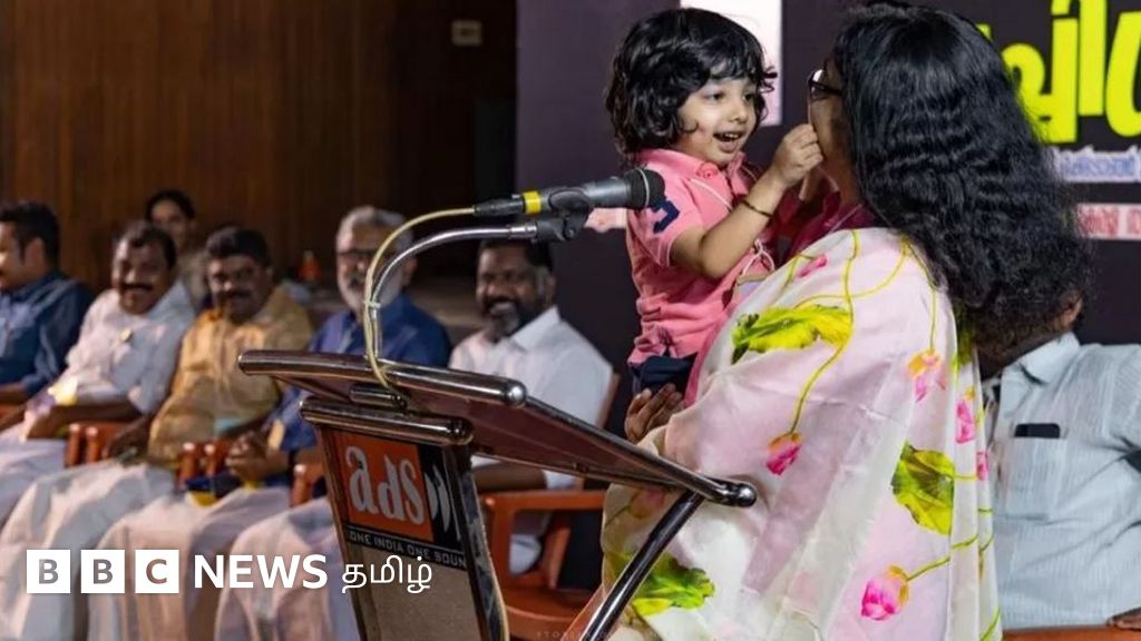 கேரளாவில் வைரலான ஆட்சியரின் செயல்: குழந்தையைக் கையில் ஏந்திக்கொண்டு மேடையில் பேசியது ஏன்?