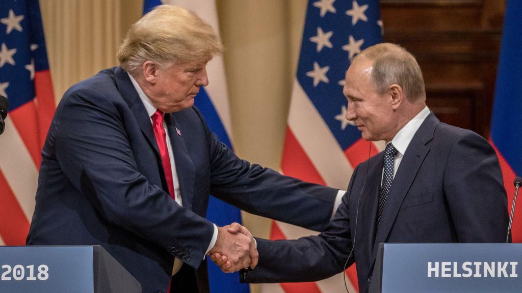 Trump and Putin shaking hands in front of a lectern reading "Helsinki". American and Russian flags are in the background