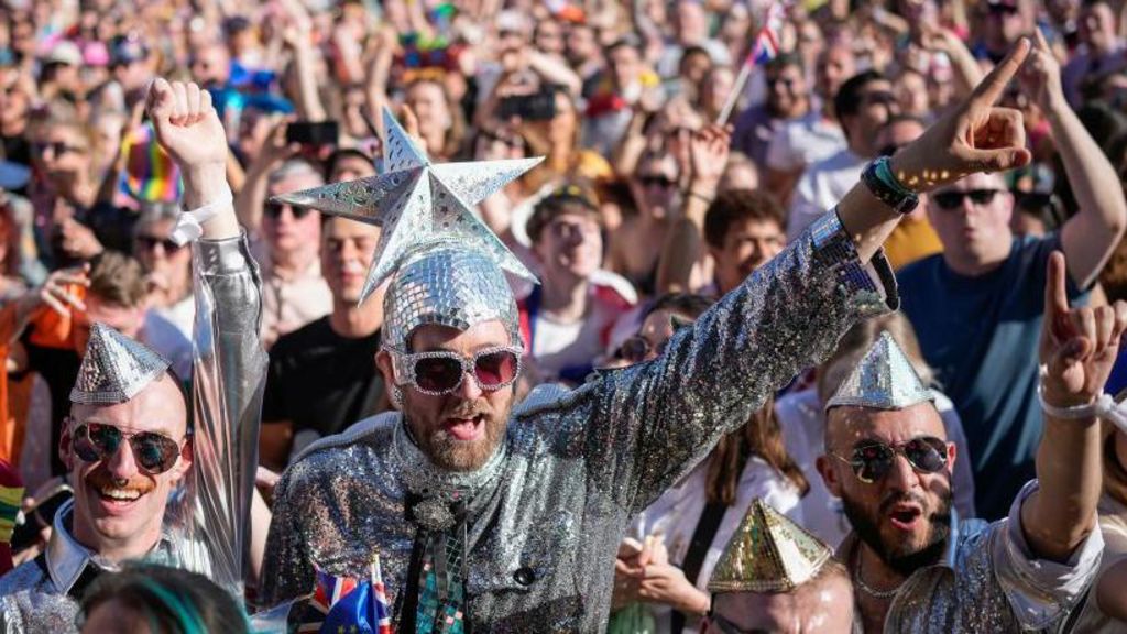 Eurovision fans dressed up in a crowd at a concert in silver costumes