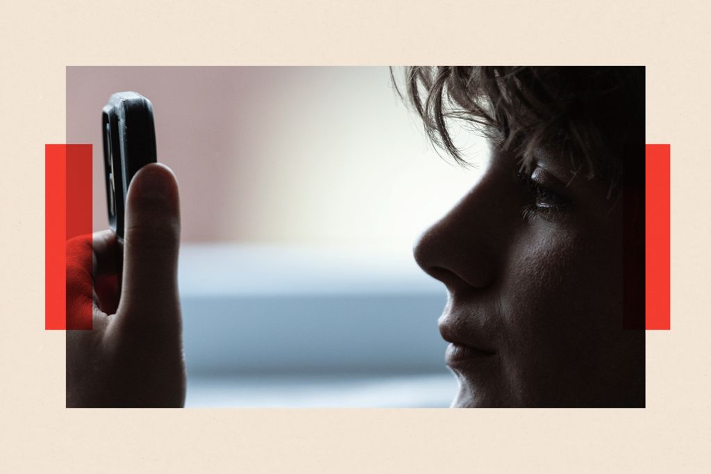 A young boy looks closely at a phone screen 