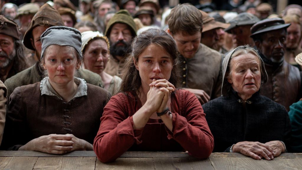 A still from Hamnet showing Jessie Buckley's character at the front of a theatre crowd