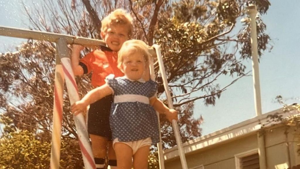 David Burton wearing a Luton kit as a child in Australia stood next to his little sister