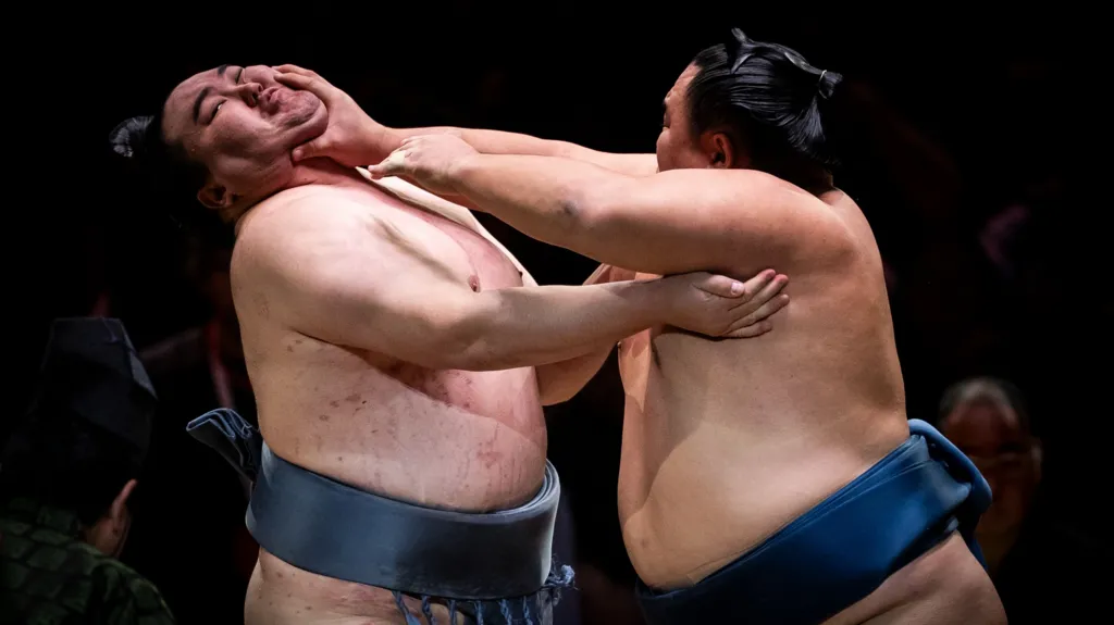 Two sumo wrestlers grappling during a match