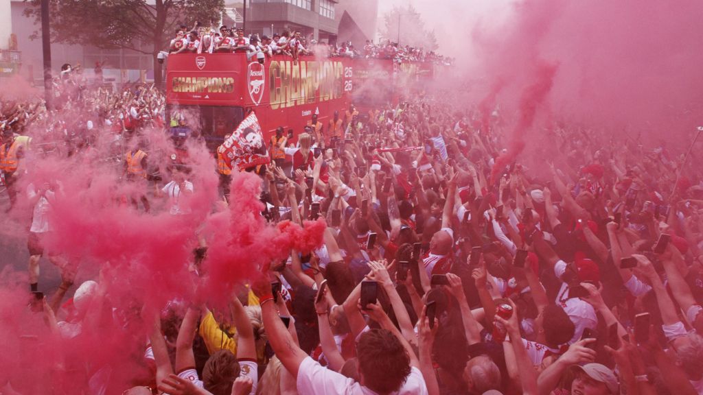 Arsenal players celebrate with the Premier League trophy on an open-top bus during Arsenal Champions Parade in north London on Sunday.