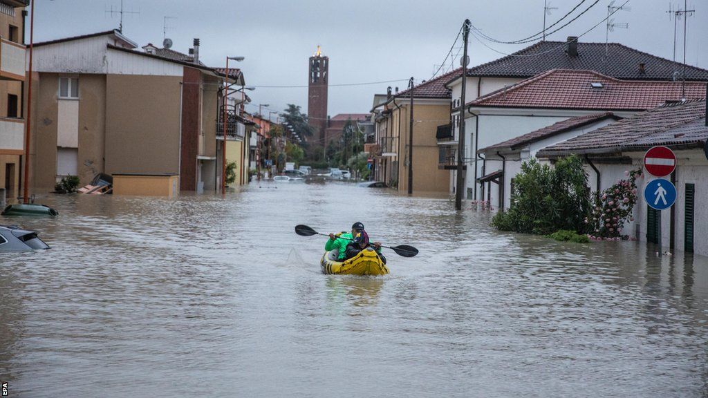 Kayak goes between the flooded houses in Cesena, Italy