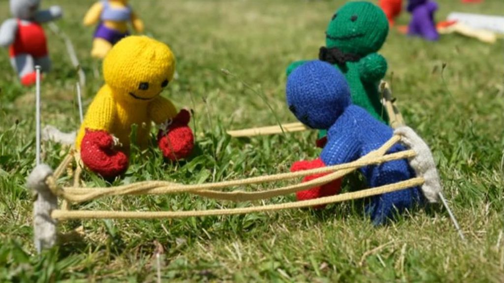 Two miniature knitted figures box in mimic boxing ring. 