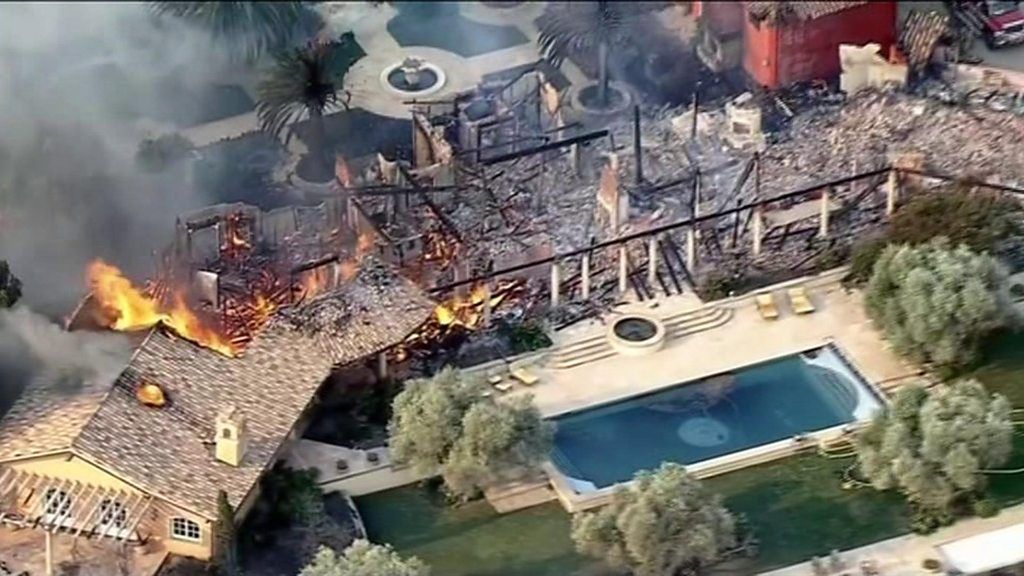 Aerial shot shows a large mansion totally destroyed by fire