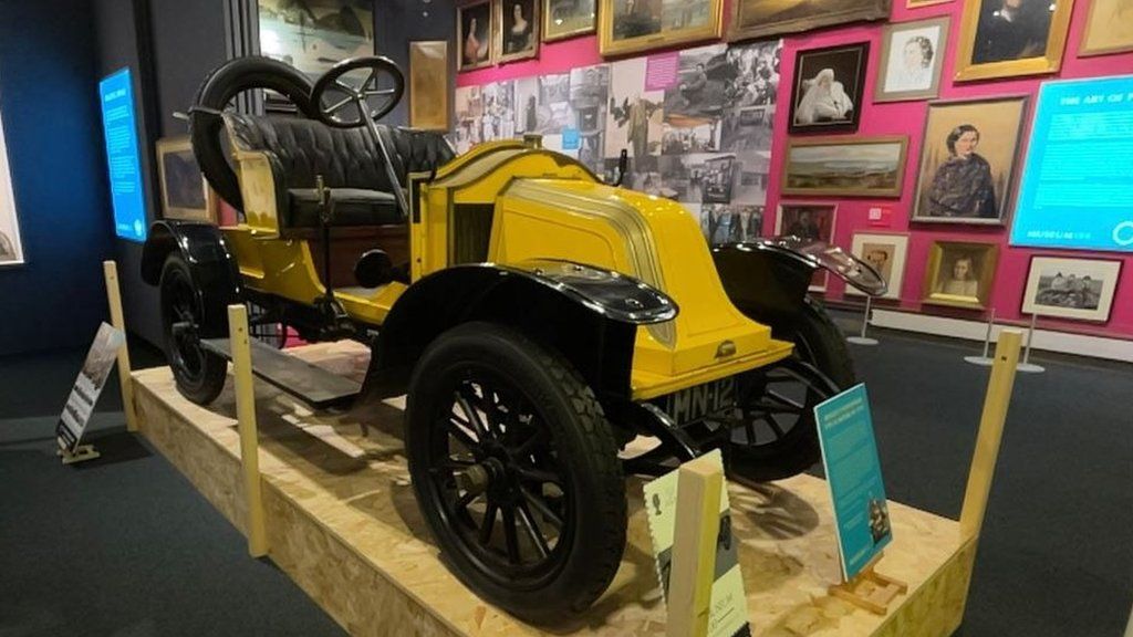 An old motor car on display at a museum