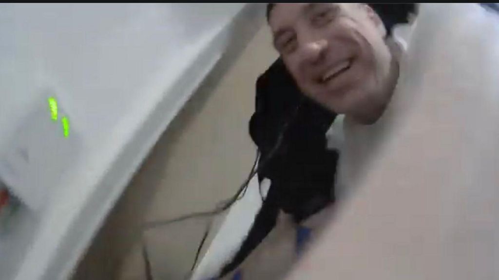 Finnlayson with short dark hair laughing, captured on bodycam footage. 