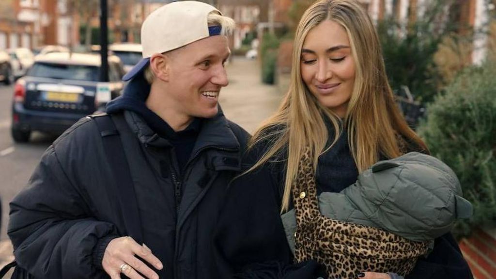 Jamie Laing and Sophie Habboo carrying a baby