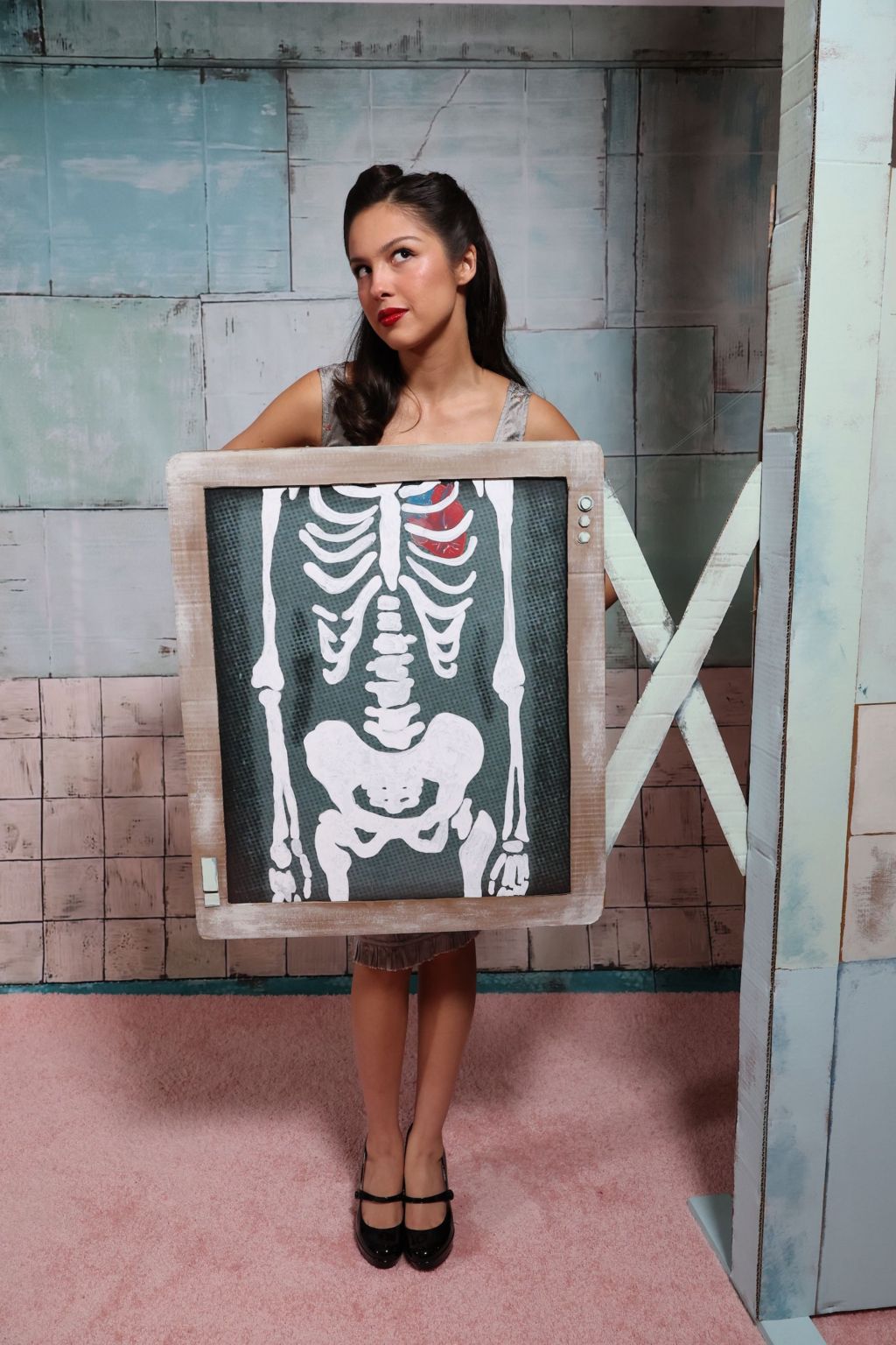 Olivia Rodrigo is pictured standing behind a mock-up X-Ray, in a promotional stunt for her single The Cure.